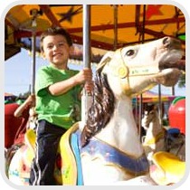 boy riding carousel at amusement park